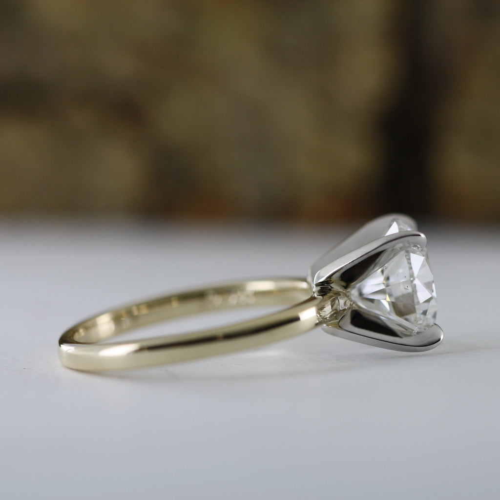 This stunning engagement ring features brilliant 4 carat round lab grown diamond set in white gold setting, beautifully complemented by a yellow gold shank. Two tone design enhances the diamond brightness creating outstanding 