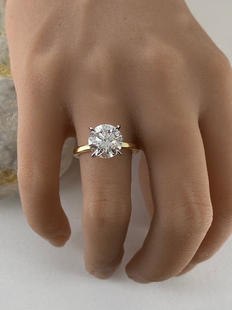 This stunning engagement ring features brilliant 4 carat round lab grown diamond set in white gold setting, beautifully complemented by a yellow gold shank. Two tone design enhances the diamond brightness creating outstanding appear,